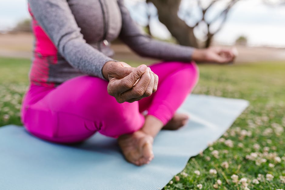 Woman performing a very gentle yoga pose outdoors near water, calm and focused